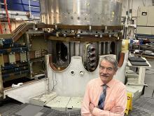 Ian Hutchinson standing in front of Alcator C-Mod tokamak