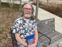 Photo of John Rice on courtyard bench